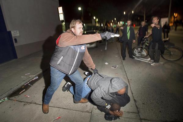 Plainclothes cop points gun at California protesters